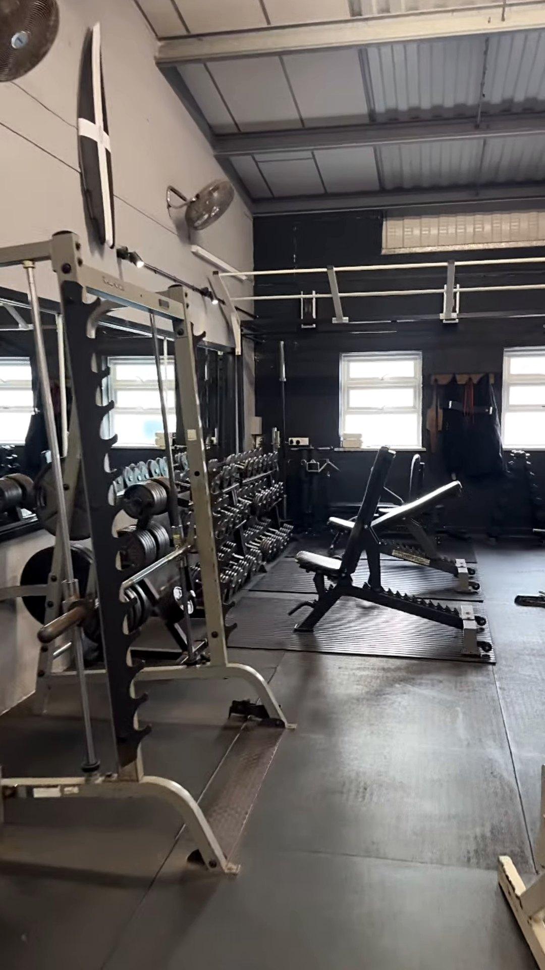 Power racks and dumbbells below the windows