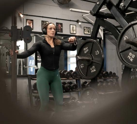 A member pressing dumbbells overhead