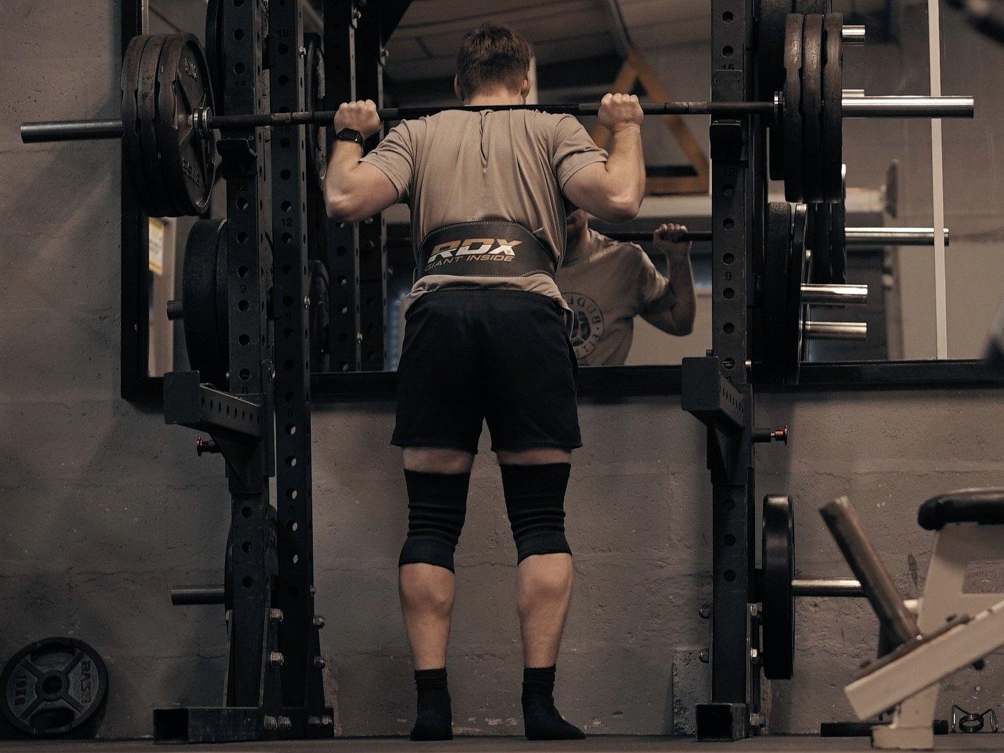 A member squatting in the power rack