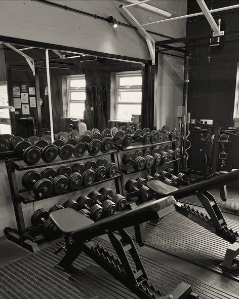 Dumbbell racks and an adjustable bench by the windows
