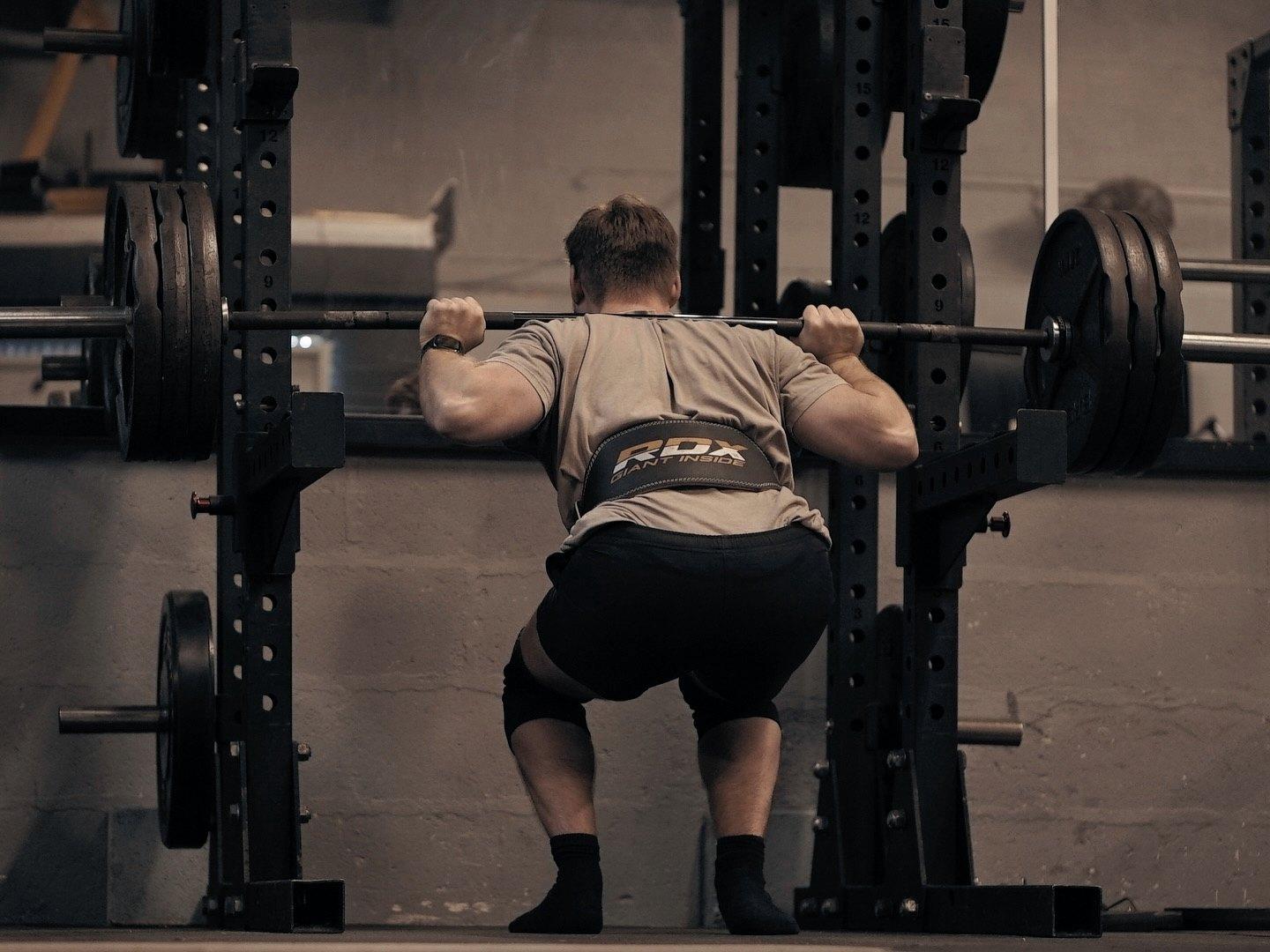 A member at the bottom of a squat in the power rack